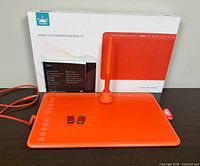 Front view of Huion HS611 tablet with pen, stand, USB adapters, cable and box