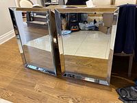 Two beveled mirrors standing on floor showing full fronts