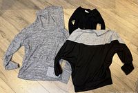 All three sweaters laid flat on floor