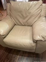 Front view of one Natuzzi dark taupe faux leather armchair