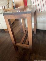 End table side perspective showing legs, stretcher base, finish