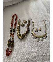 Assorted necklaces and earrings on bedspread
