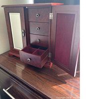 Cabinet shown open displaying drawers, mirror door, right side door