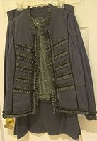 Jacket displayed on hanger over sleeveless top and skirt beneath