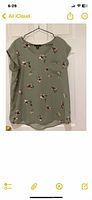 Green floral short-sleeve blouse on hanger