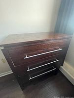 Front view of dresser showing three drawers and metal pulls