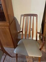 Teak armchair showing slat back, arms and upholstered seat