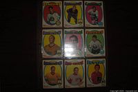 Front view of nine 1971-72 O-Pee-Chee hockey cards in binder page showing team names and player images