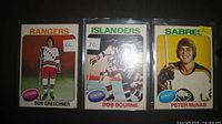 Fronts of three rookie hockey cards in plastic sleeves