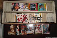 Open 2-row card box showing numerous hockey and baseball cards, several featured cards displayed on table for reference