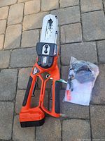 Overall view of lopper with battery attached and charger bag