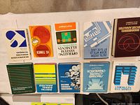 All ten textbooks arranged spine up upside down, showing covers