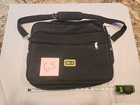Front view of black B&H computer bag with tape measure showing length
