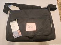 Front view of black Belkin laptop messenger bag with hang tag and lot note