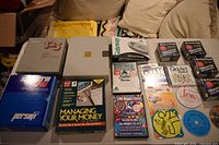 Overview of entire lot on table, showing boxed software, FujiFilm floppy packs, promotional CDs