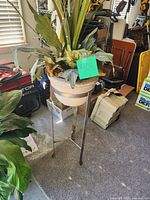 Full view of concrete planter, metal stand, artificial plant