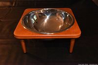 Stainless steel bucket seated in wood stand