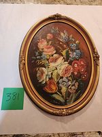 Full view of oval floral oil painting with frame
