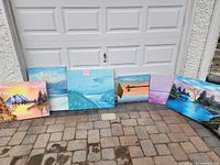 All six canvases lined against garage door