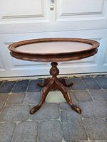 Full front view of oval side table showing pedestal base and rim