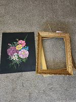 Oil painting and empty gilt frame on floor