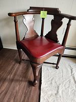 front/side view of wooden corner chair showing red seat and splats