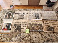 All items laid out: four newspapers, signed photo, calendar page