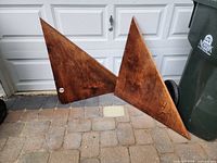 Two triangular wood shelves leaning against garage door