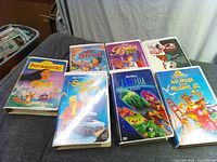Seven VHS tapes laid out showing front covers