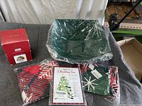 Overview showing green bowls pack, Hallmark ornament box, two fabric gift bags, Roll-A-Tree game