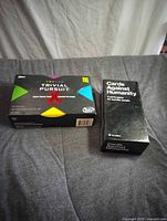 Trivial Pursuit and Cards Against Humanity boxes side by side
