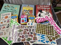 All items laid out: three hardcover children’s books, three flash card packs, multiple sticker sheets with alphabets, numbers, science icons and assorted motifs