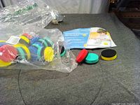 Bag of assorted magnetic circular whiteboard erasers and instruction sheet