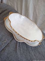 Bowl nested on platter showing gold trim and relief grape motif