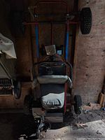 Top view of complete go-kart hanging vertically, showing frame, seat, wheels