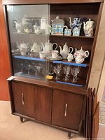 Full view of cabinet front showing glass display, lower storage, and hardware