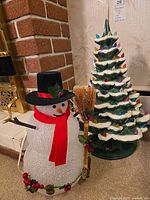 Ceramic tree and acrylic snowman standing together showing overall appearance