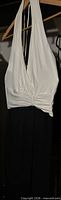 Front view of gown on hanger showing white halter top and black skirt