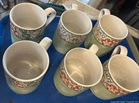 Top view of six mugs on tray showing interior condition and pattern