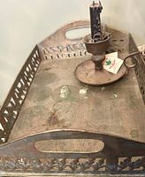 Full view of tray, chamberstick with candle and matchbook showing patina and wear