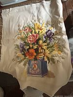 Full view of embroidered panel showing bouquet in cocoa tin on fabric
