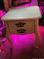 Front and side view of nightstand showing drawer front, legs and finish