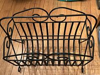 front view of black scrollwork metal magazine rack