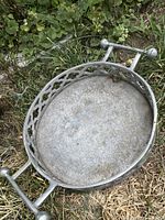 Overall view of cast metal tray showing pierced rim, handles and weathered finish