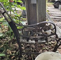 Left side of bench showing ornate cast iron frame and missing seat slats