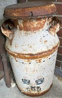 Full view of milk can with lid, handles, painted hearts, rust