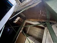 Underside showing wooden top, green metal braces, wear