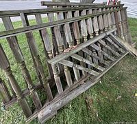 Stacked wooden porch railing sections showing turned balusters and weathered condition