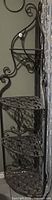 full view of wrought iron corner etagere showing four shelves and scrollwork