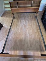 Twin bed frame assembled showing rails and flooring footprint